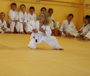 Foto: Mädchen im weißen Gürtel auf einem Knie